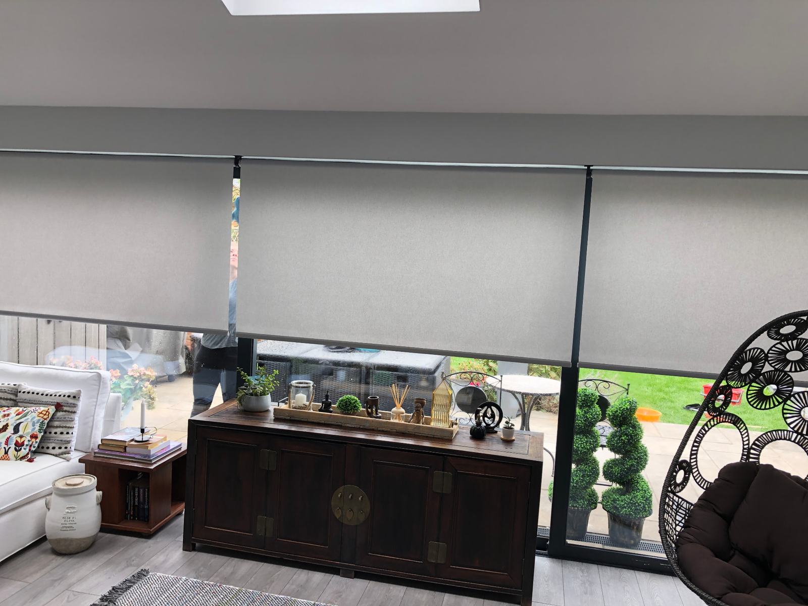 Made-to-measure grey roller blinds fitted across floor-to-ceiling windows in a Richmond home